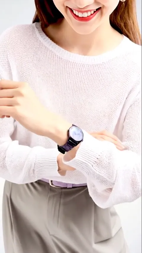Her arm extends, the watch at the centre. The case is small against the wrist — a parameter that tells a buyer nothing w