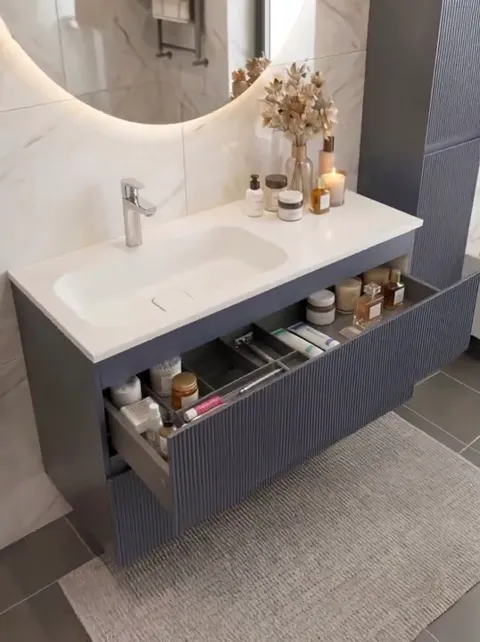 A drawer rolls out: dividers inside with cosmetics neatly arranged. The depth is visible, and the organiser is built in 