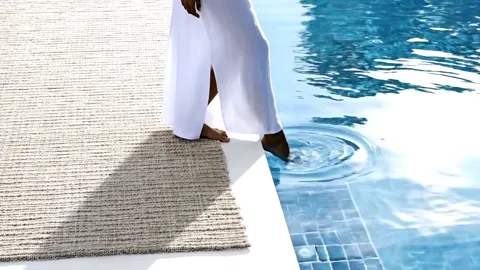 The finale: the woman at the water, the rug lying flat, no wind in it. Eight seconds have explained the word Performance