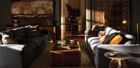 The finale: the room in warm sunset light, both sofas in frame. Ten seconds have shown not a single object but an assemb