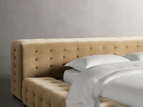 The camera pulls back to the whole bed: a low platform, a wide headboard, side rails in the same buttoning. White linen 