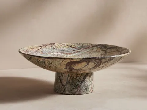 The light shifts and the veining on the rim sharpens. The figure does not repeat: on this side of the stone the pattern 