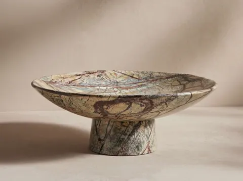 A lower frame brings in the foot. Bowl and base are turned from one block — the line of the veining continues from rim t