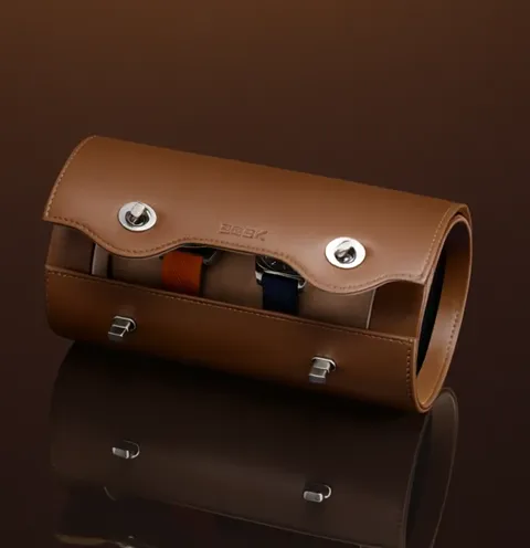 The flap lifts and straps appear beneath it — one orange, one navy. A turning-point frame: before it this is just a leat