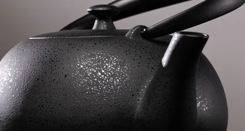 The light moves left and the grain lights up in silver points. The same patch of surface looks different — the glaze doe