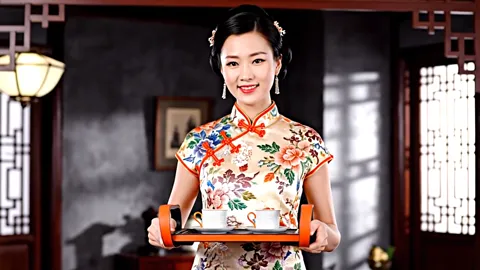 The finale: she looks at the camera, the tray in front of her. Eight seconds have shown the object in hands rather than 