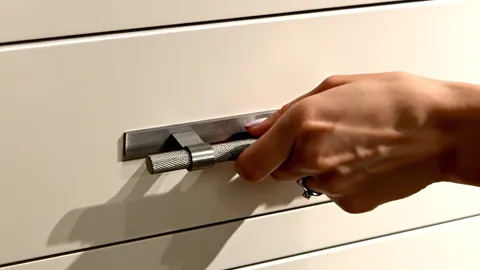The fingers close around the bracket. The section of the handle is visible: not round but faceted, with a flat for the f