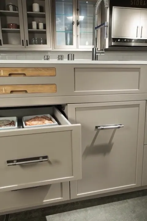 A lower drawer rolls out: trays of food inside. It is not simply a drawer but a refrigerated compartment on full extensi