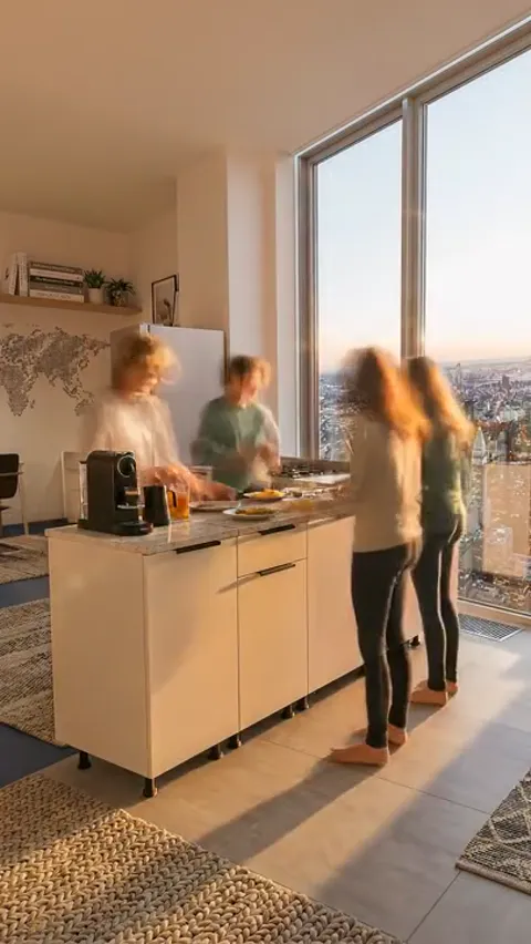 Day turns to evening, the window light going orange. The people are still blurred and the island modules have not moved 