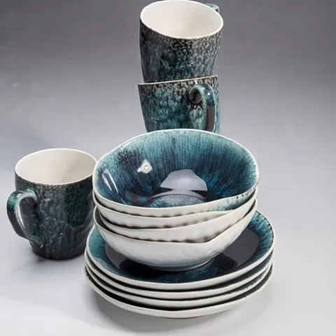 The ground goes near-black. The glaze is glossy and catches a highlight at the rim, and the turquoise-to-white transitio