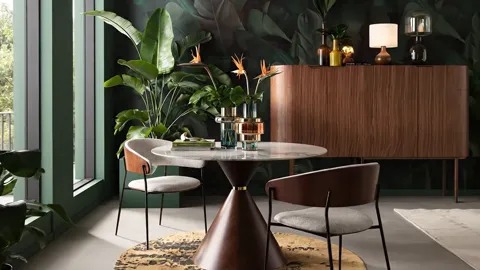 Closer to the table: a marble top with grey veining, glasses on it. The chairs have curved backs on slim black legs.