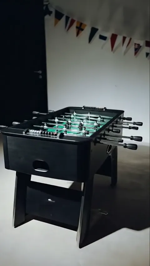 The ground darkens, the table at three-quarters. The player figures are legible, and the pitch is marked out rather than