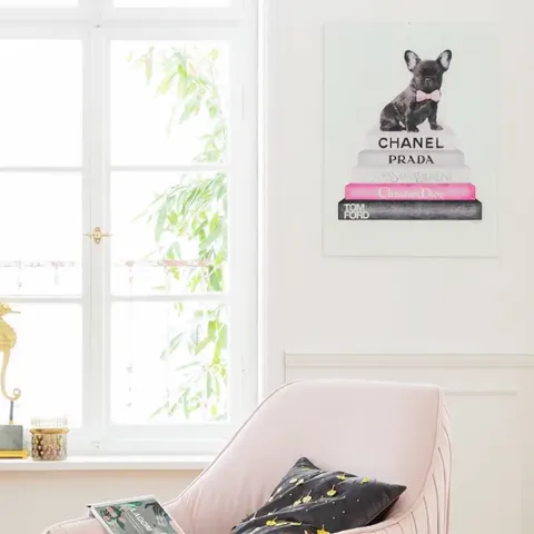 A bright room with arched windows: on the wall, a picture of a French bulldog sitting on a stack of books. A pink armcha