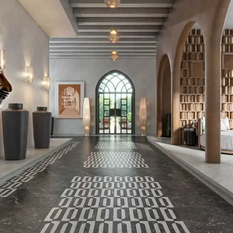A long vaulted hall: arches, lamps, shelving along the walls. The floor is laid in black stone with a white geometric or