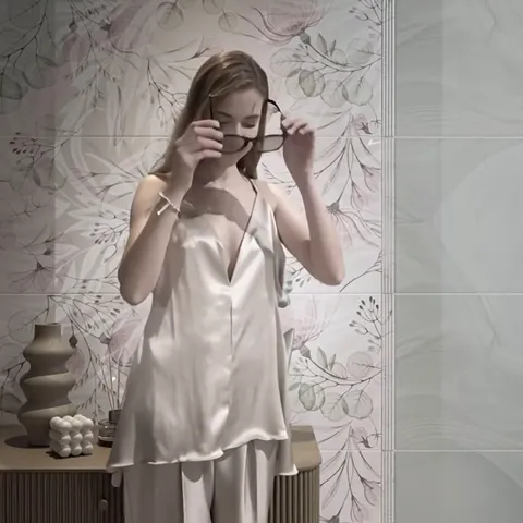 The woman, centre frame, puts on her glasses. Her figure covers part of the wall — and the contrast shows how pale the p