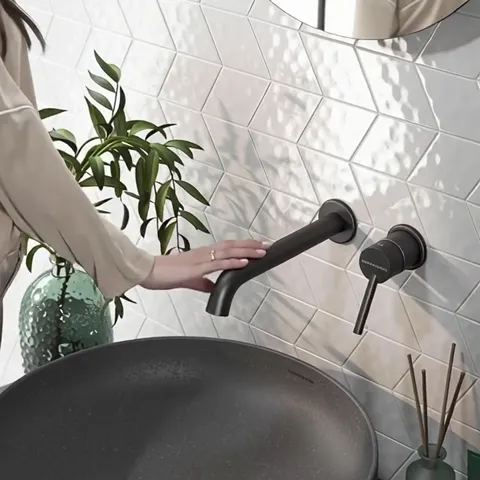 A hand enters and touches the spout. The scale is set: a diamond is about half a palm, the tap is short, the reach over 
