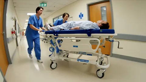 The trolley runs straight and the staff keep their pace. Two people handle it without effort — the castors swivel and th