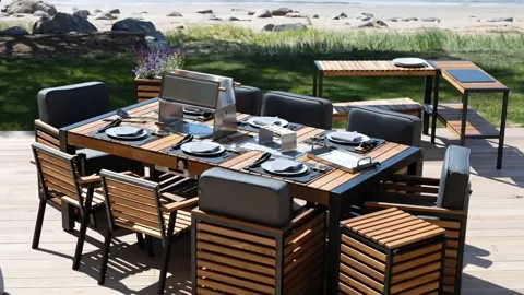 The camera travels along the table. The grill occupies the end while the main area stays free for plates — this is a din