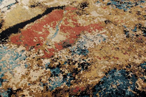 Closer, and the structure of a patch becomes visible: the colour is built from a fine speckled mix of yarns, not a solid