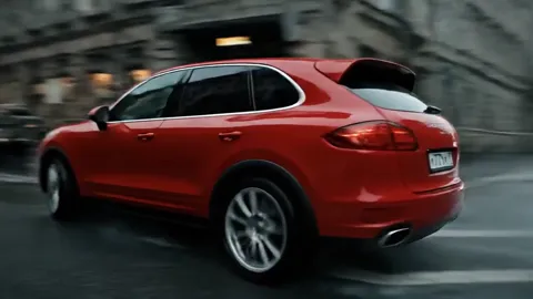 The car in profile at speed. Wheels and arches in focus, the background smeared — speed carried by blur rather than by a