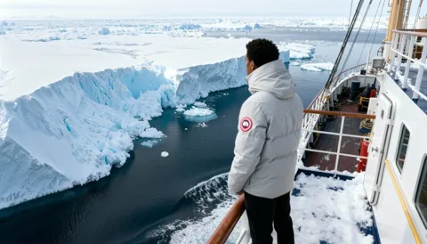 The finale: the man looks at the glacier, the parka entire in frame. Ten seconds have shown the garment in the environme