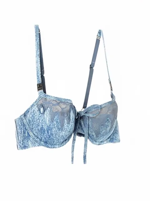 The bra on an invisible mannequin against white: pale blue fabric in a faded denim-look print, thin adjustable straps, a