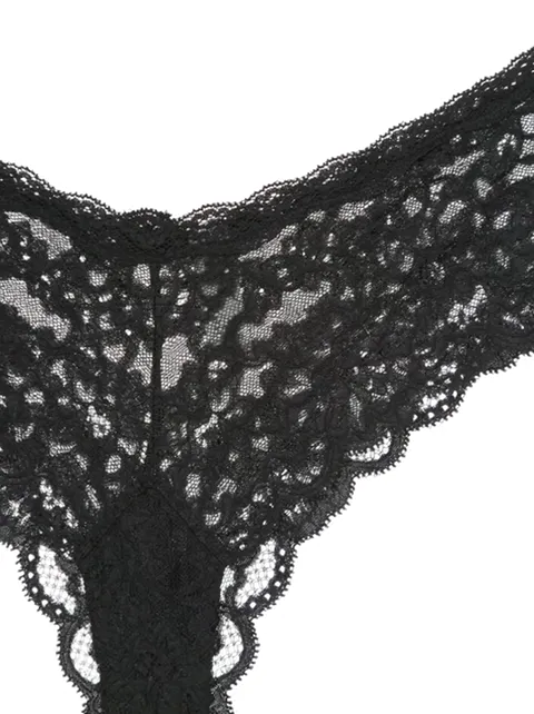 A close frame on white: black lace with a large floral repeat and a scalloped edge. The openings in the lace show right 