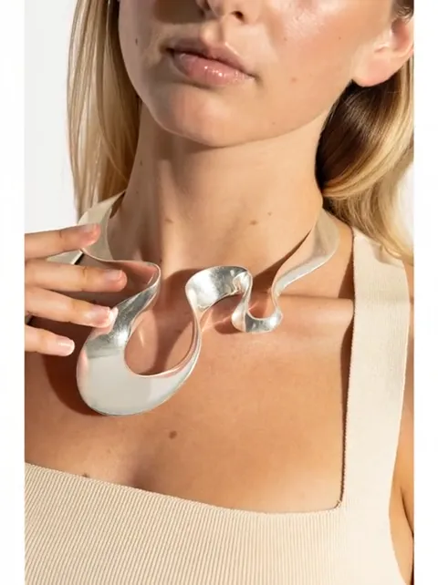 The head turns and the choker shifts. The ribbon holds itself on the neck — the rigid form does not close with a clasp.