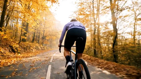 The bike recedes down the road, the camera still. The aerodynamic tube profile and the deep-section rims are legible.