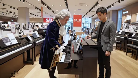 The finale: both at the keyboard, the floor behind them. Eight seconds have said more about the shop than a window full 