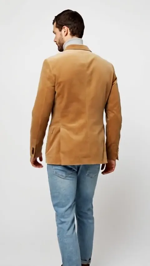 He turns his back. The back is one panel with no vent, and the corduroy wale runs vertically along its whole length.