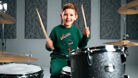 A hit on the cymbal, hands in motion. The sleeve rides up and reveals the cuff — the ribbing is firm and the sleeve does