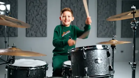 The finale: he smiles at the camera, sticks up. Eight seconds have shown a children's garment in motion — how it behaves