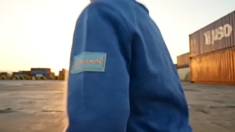 Macro on the sleeve from behind: the brand label at the elbow. It is stitched rather than glued, with the seam running r