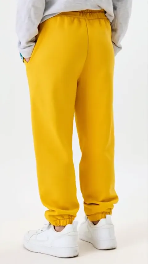 Turning to profile: the volume of the leg is visible, loose along its whole length rather than tapering at the knee.
